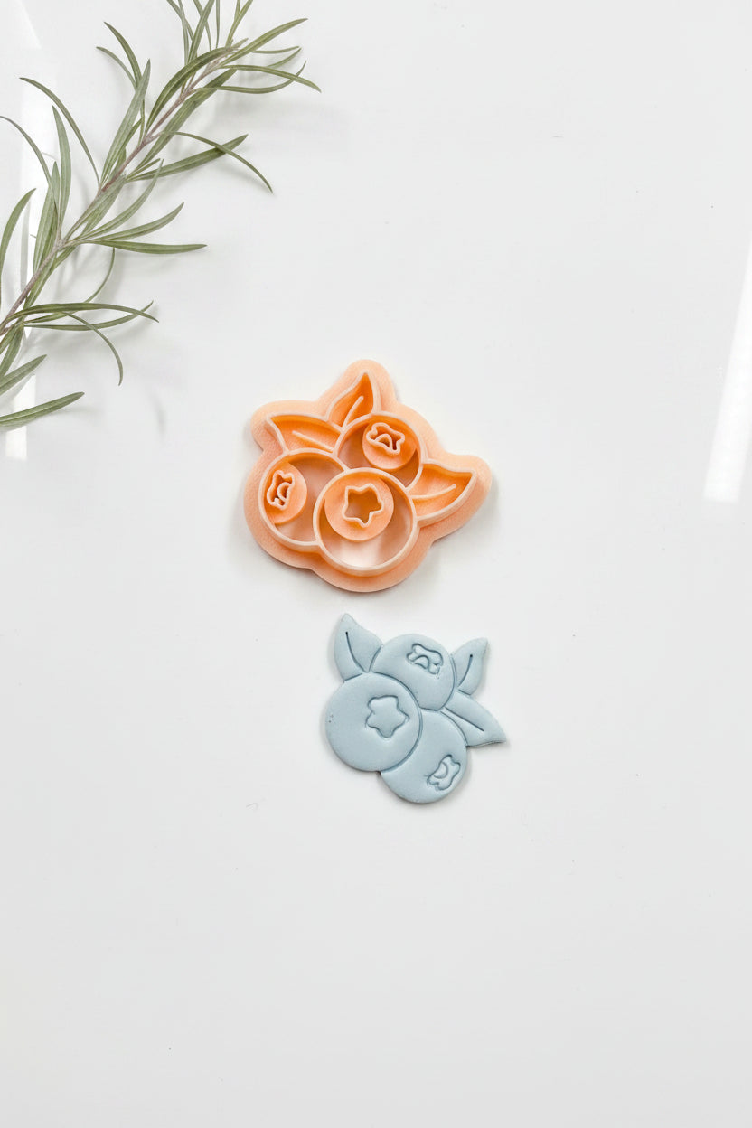 Blueberry bushel polymer clay cutter by Petal & Posy, shaped for crafting blueberry-themed clay projects.