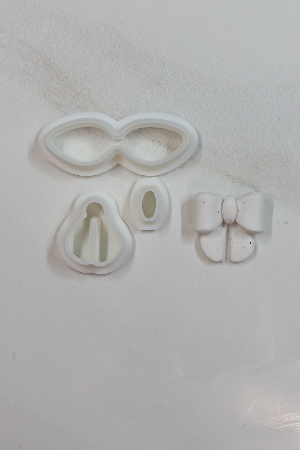 Petal & Posy petite bow polymer clay cutter set with various bow shapes for crafting and jewelry making.