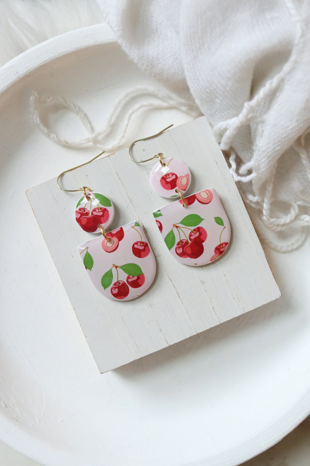 Petal & Posy Cherry Bomb polymer clay earrings featuring vibrant red cherry designs on gold hooks.