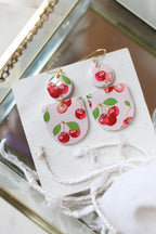 Cherry Bomb polymer clay earrings with red and black cherry designs, crafted by Petal & Posy for a stylish accessory.