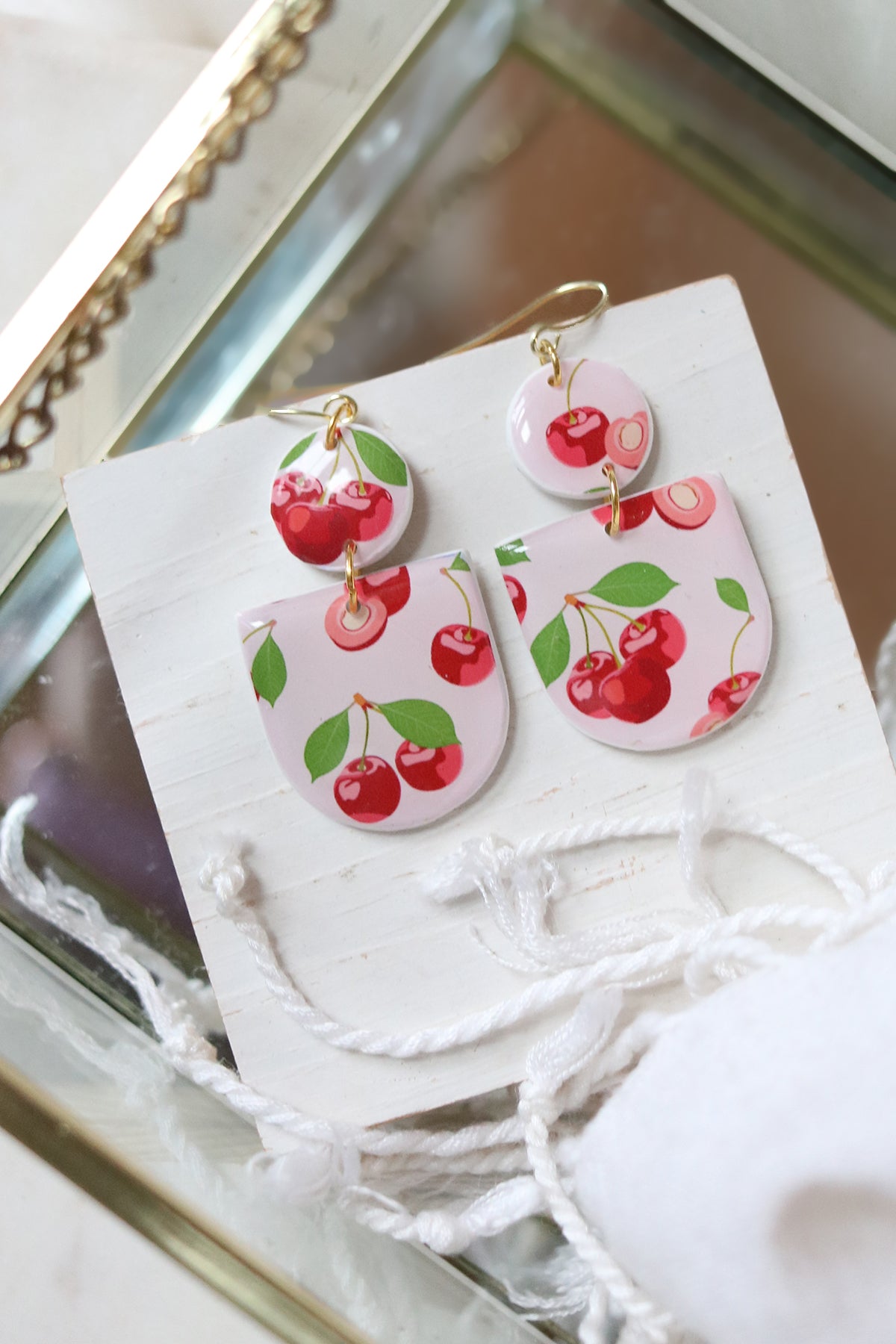 Cherry Bomb polymer clay earrings with red and black cherry designs, crafted by Petal & Posy for a stylish accessory.