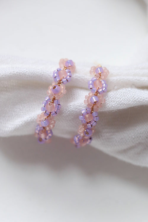 Lilac beaded hoop earrings with daisy chain design from Petal & Posy, featuring intricate hand-beaded details and gold-tone hoops.