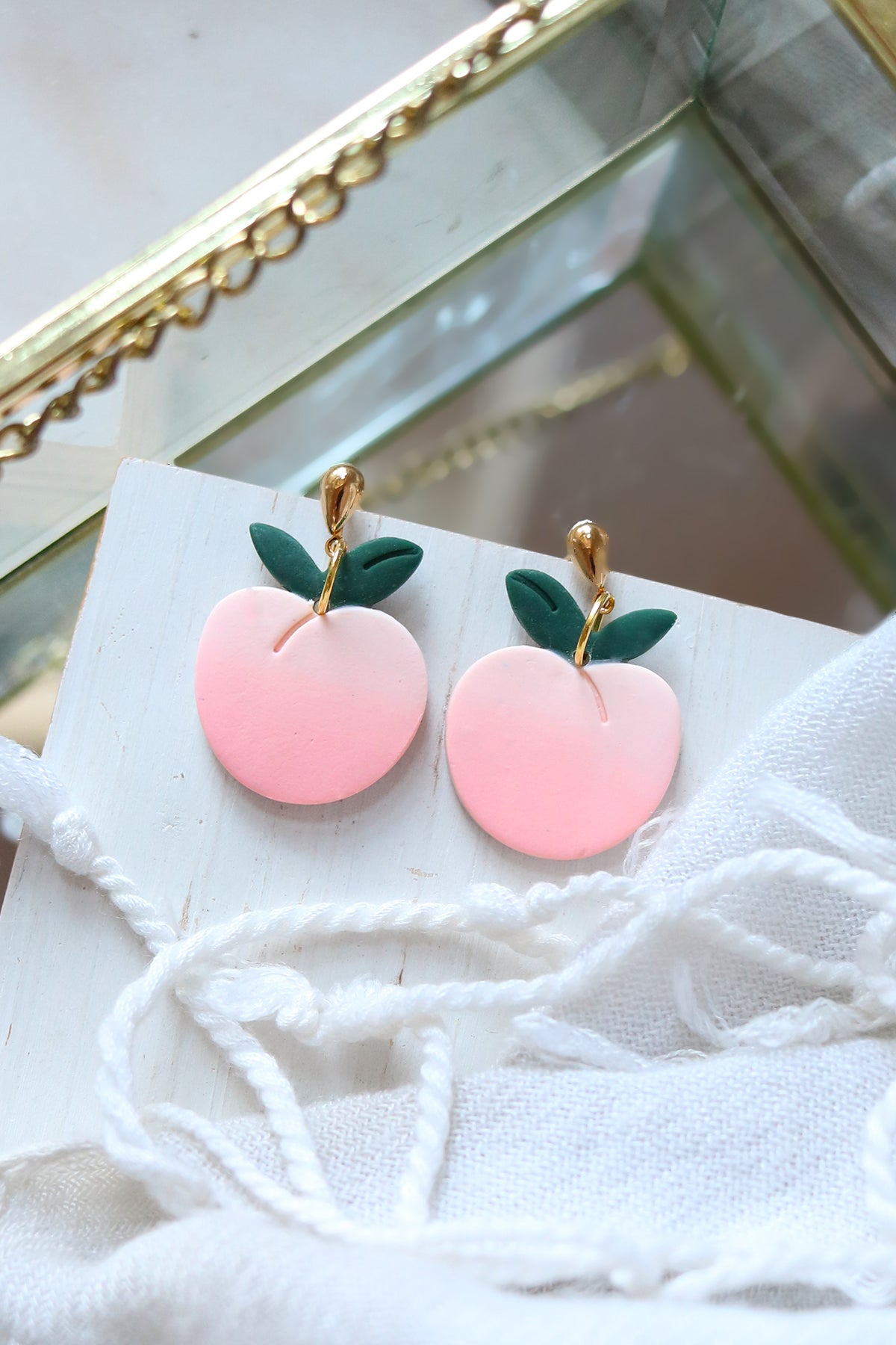 Petal & Posy sweet peach dangle stud earrings featuring peach-shaped charms with delicate gold accents on a white background.
